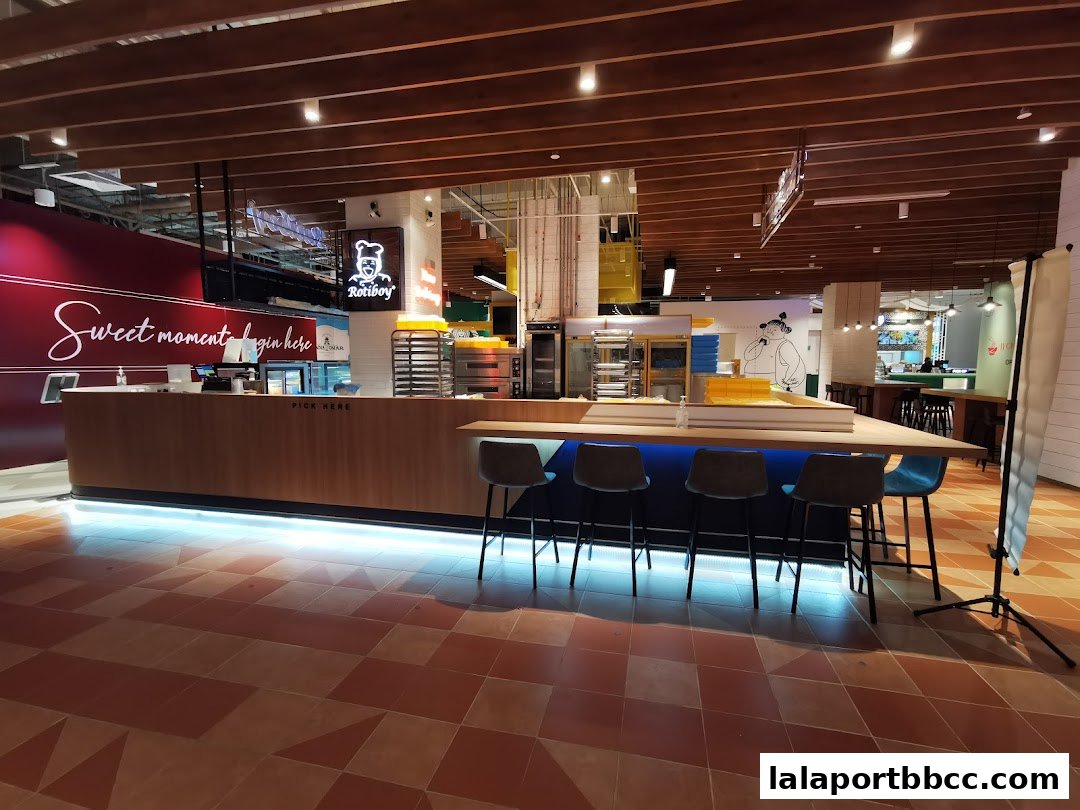 Interior view of a Rotiboy bakery counter with seating and baking equipment.