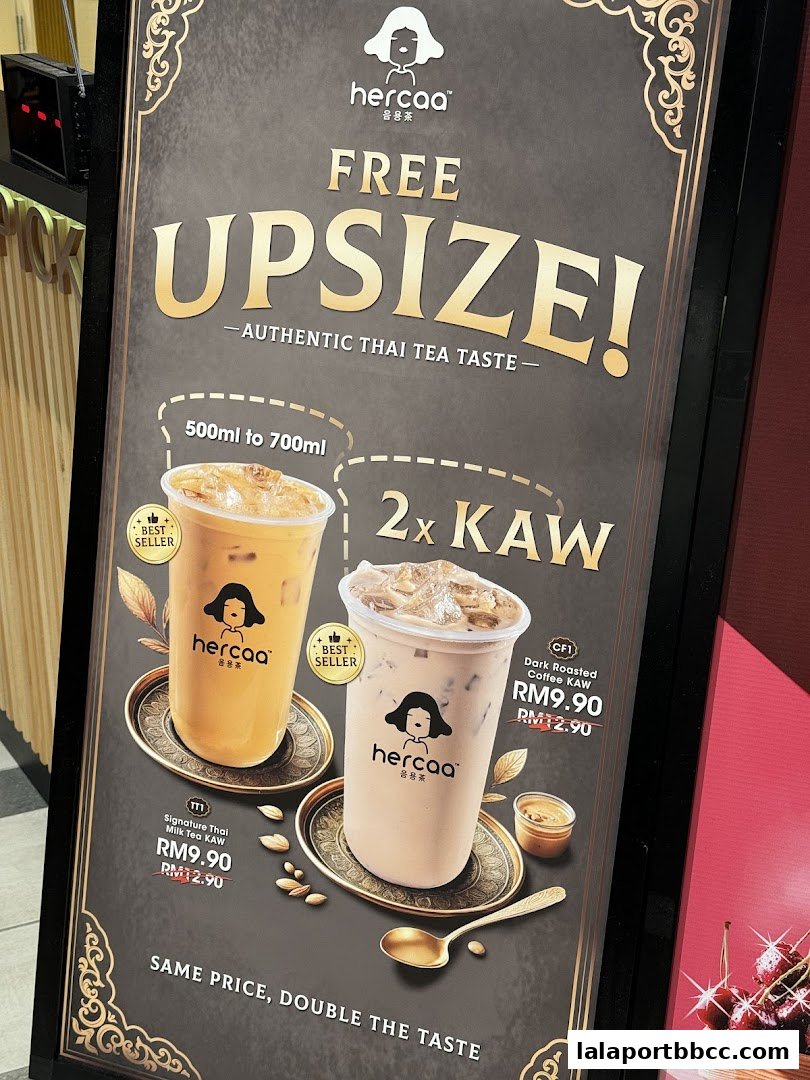 A promotional sign for Hercaa offering a free upsize on authentic Thai tea and coffee drinks.