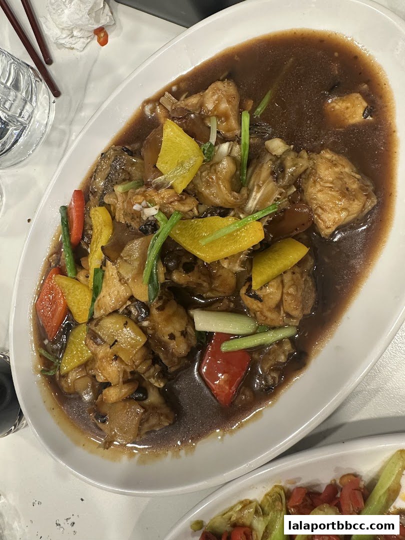 A close-up of a delicious dish with chicken, bell peppers, and scallions in a savory sauce.