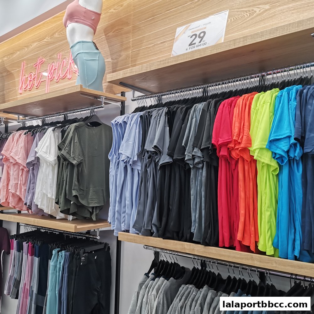 A display of colorful t-shirts and activewear on hangers in a retail store.