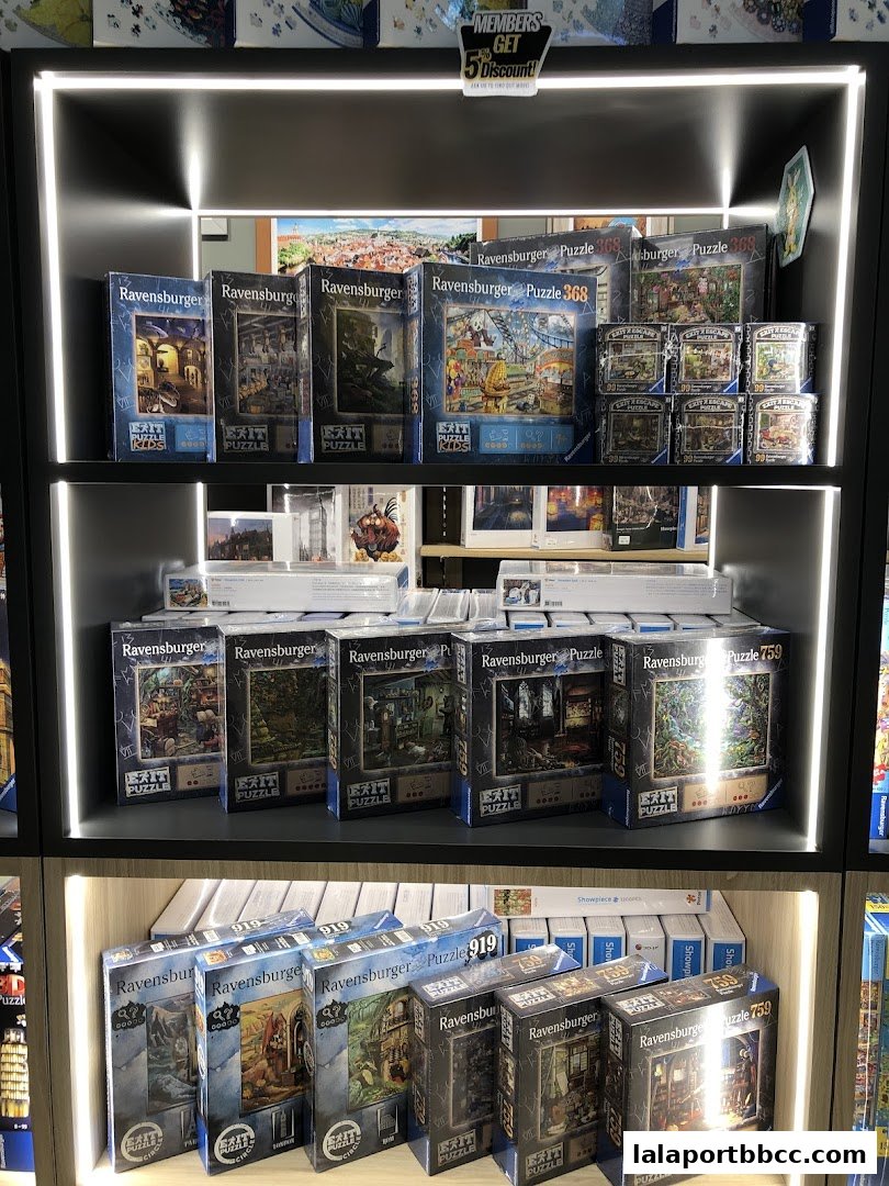 Shelves filled with Ravensburger puzzles, including Exit Puzzles and various themed puzzles.