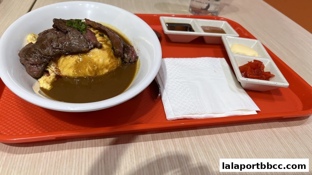 A delicious looking beef omurice with curry sauce and side condiments.