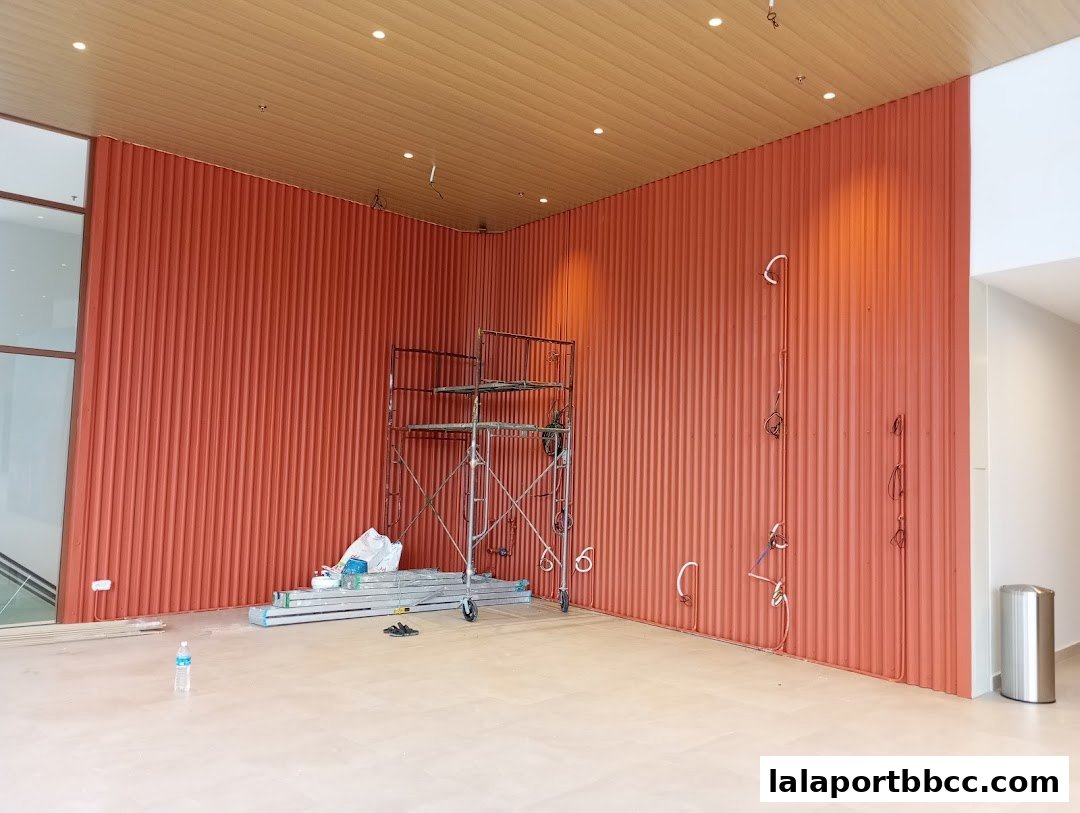 Interior of a room under construction with orange ribbed walls and scaffolding.