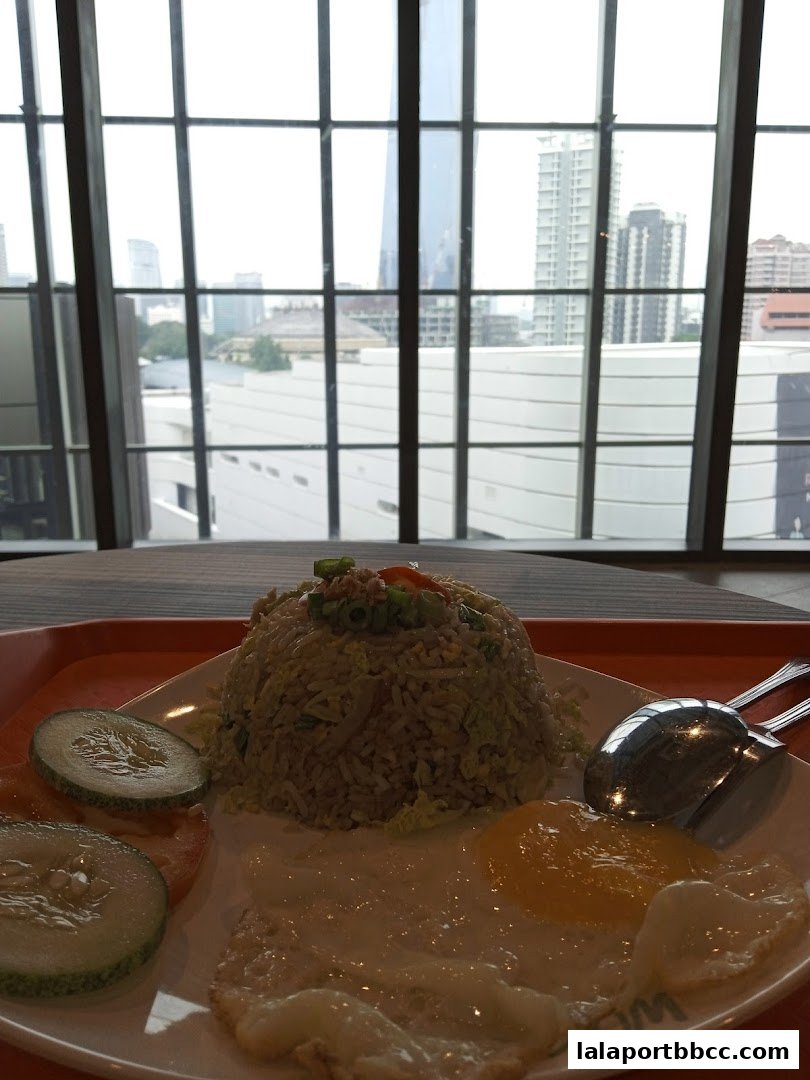 A plate of fried rice with a fried egg and cucumber slices, with a city view.