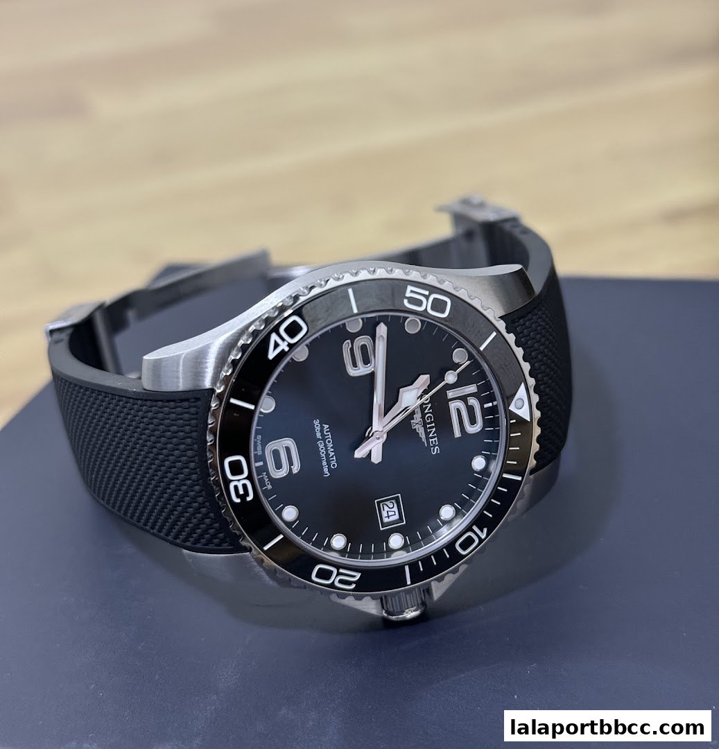 A close-up shot of a black Longines automatic watch with a rubber strap.