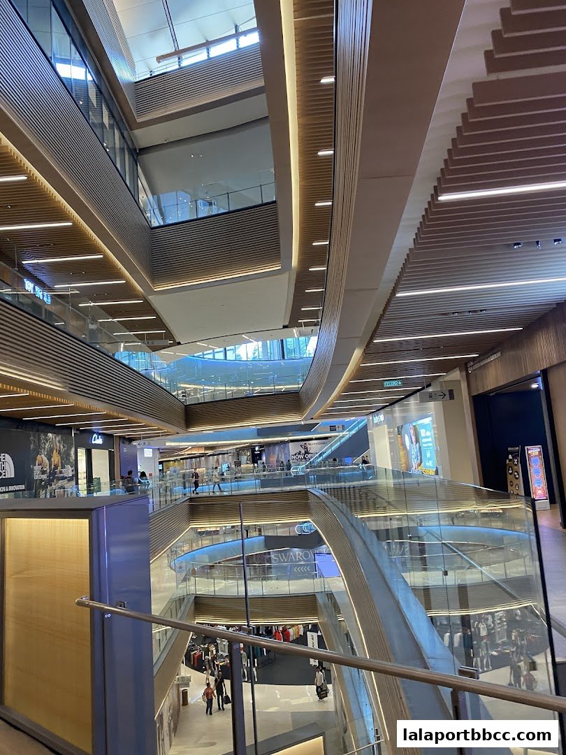 Interior view of a modern shopping mall with multiple levels and escalators.