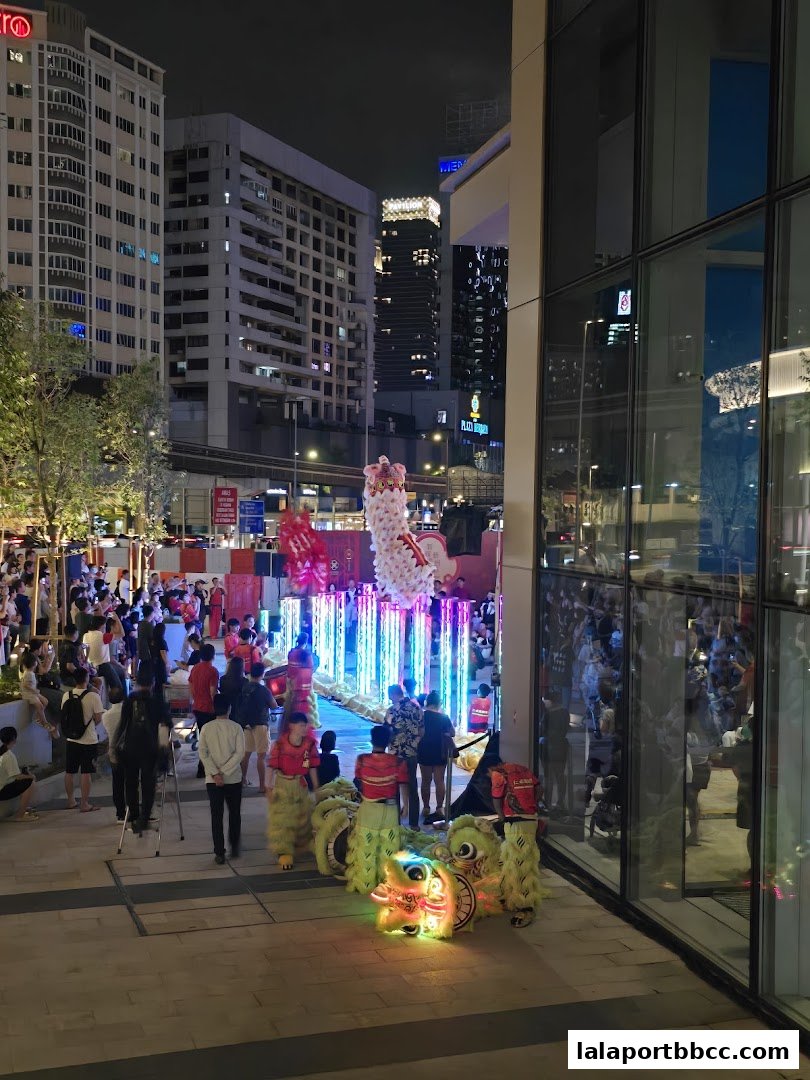 Lion dance performance with colorful lights and a crowd at night.