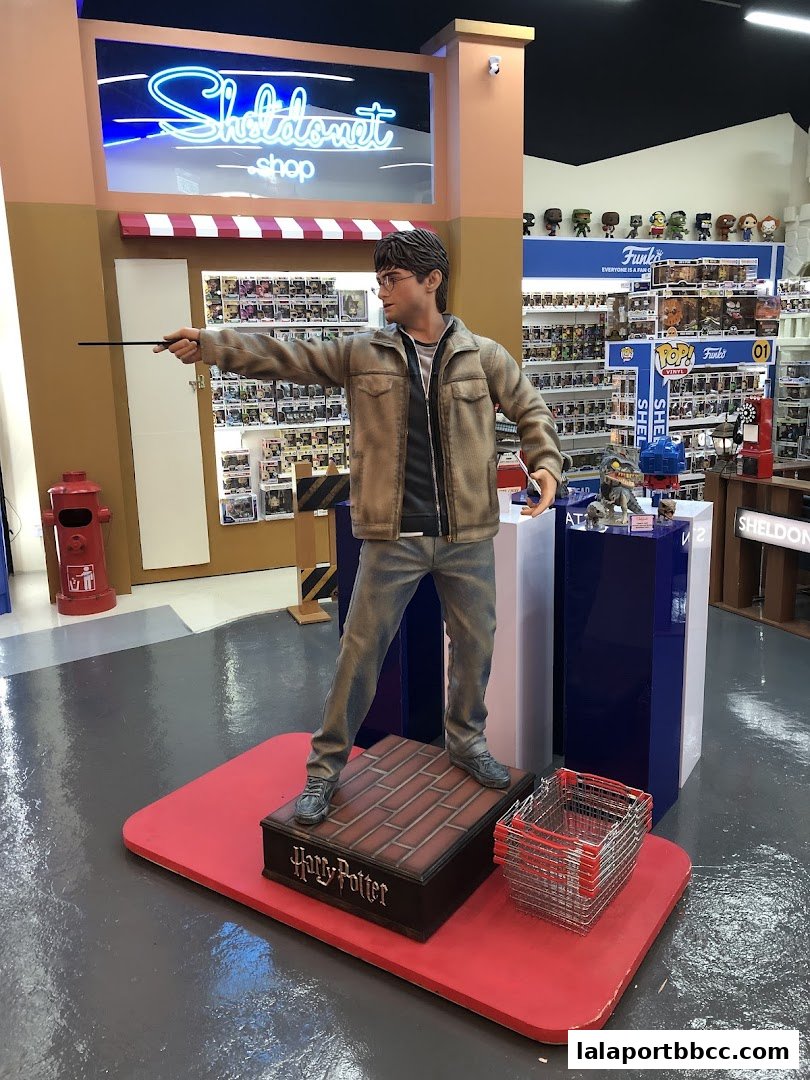 A Harry Potter statue stands in front of a toy store with shelves of Funko Pop figures.