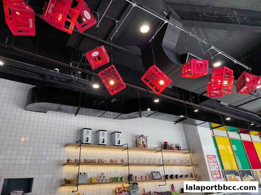 Interior of a shop with Coca-Cola crate lights and shelves stocked with goods.