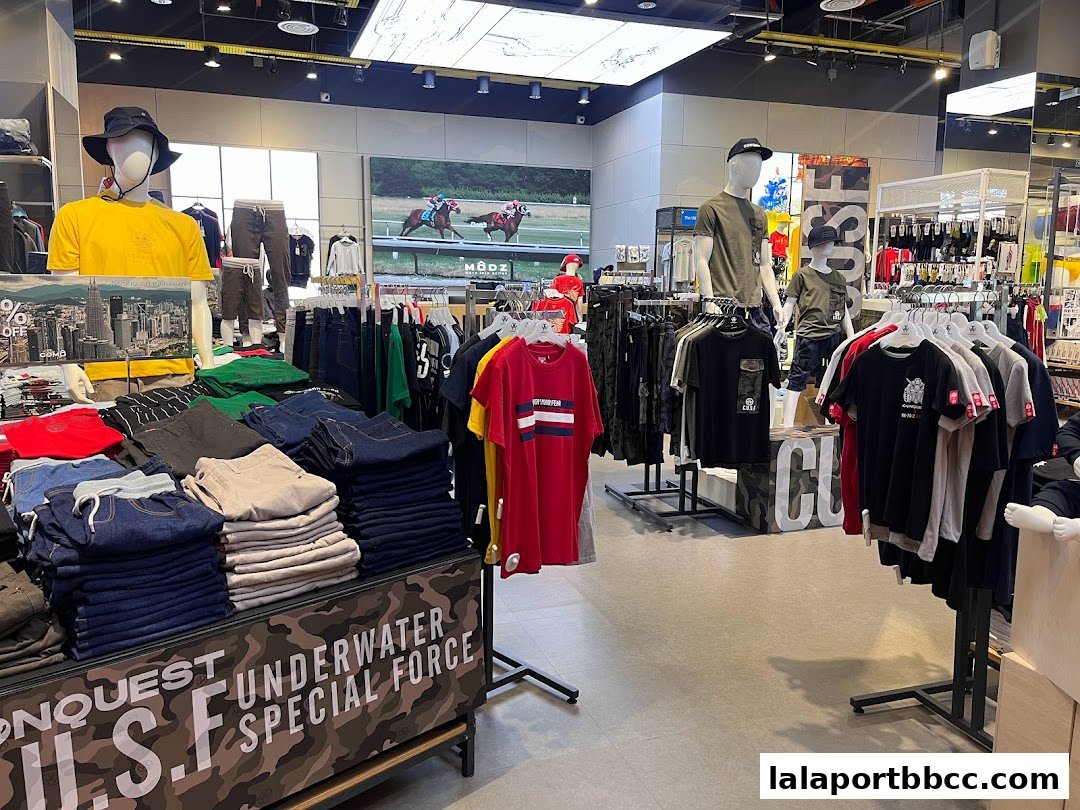 A well-lit clothing store interior with mannequins and folded apparel on display.