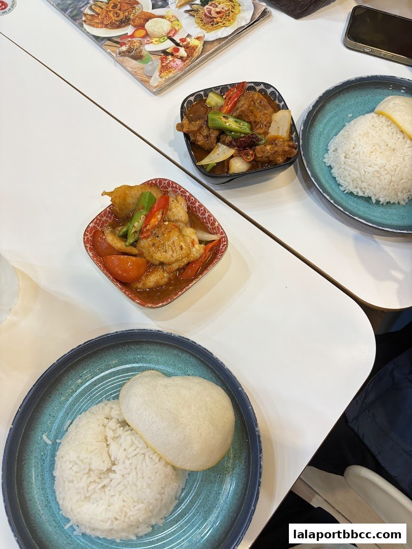 A table at Restorant Syok Makan with two rice dishes and two bowls of food.