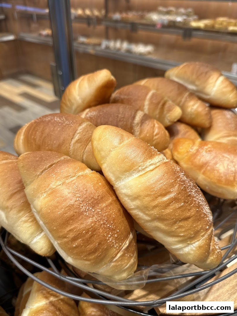 A close-up shot of freshly baked, golden-brown crescent rolls in a basket.