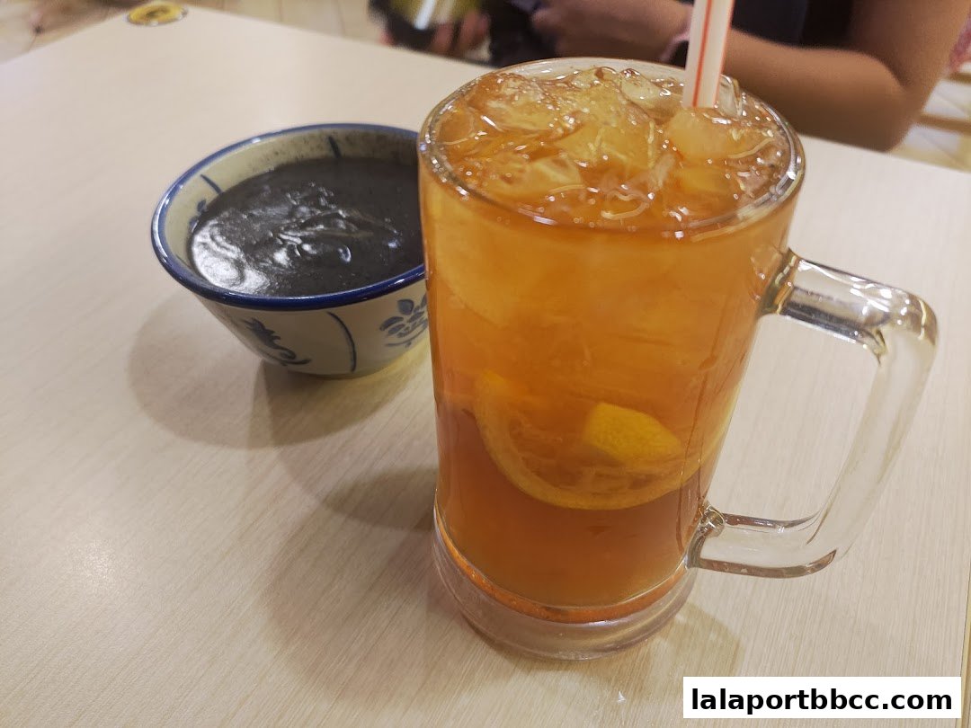 A refreshing iced tea with lemon slices and a bowl of black sesame paste.