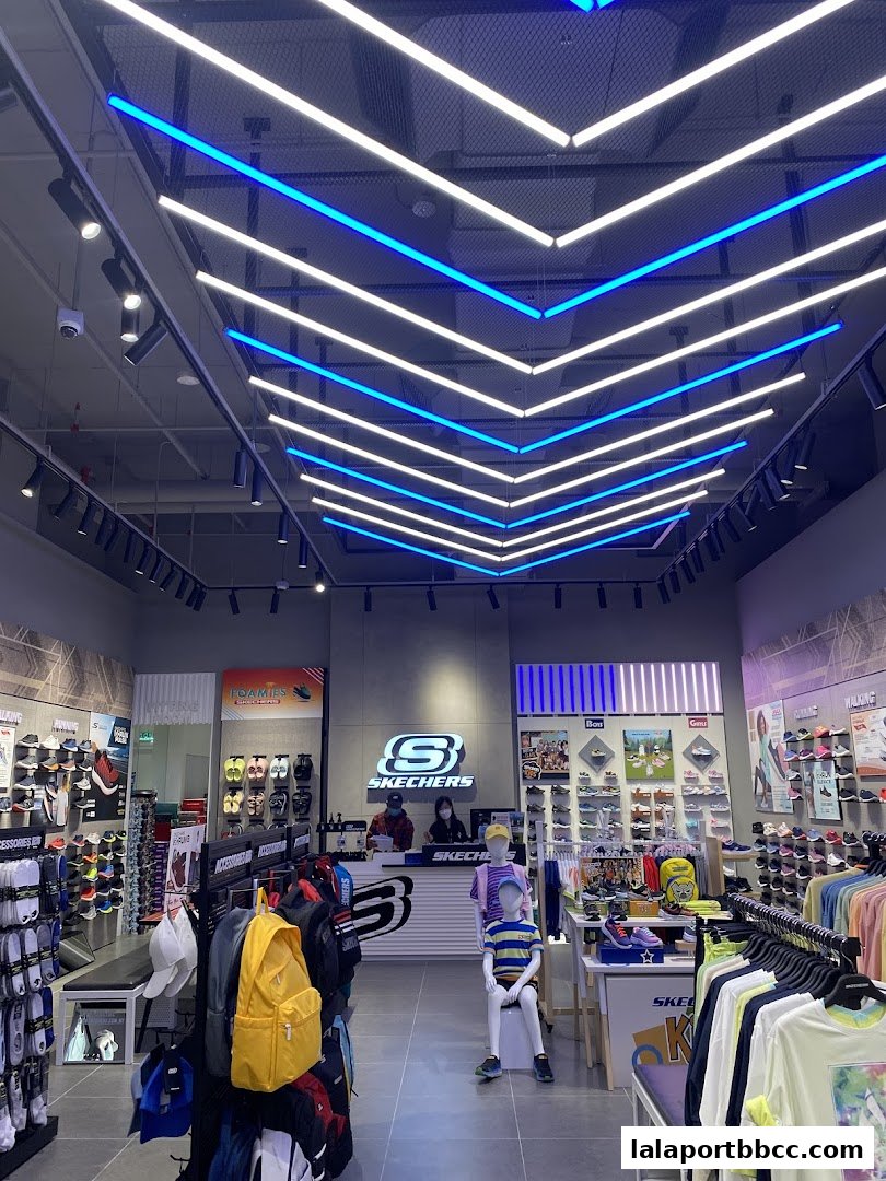 Interior view of a Skechers store showcasing footwear, apparel, and accessories with modern lighting.