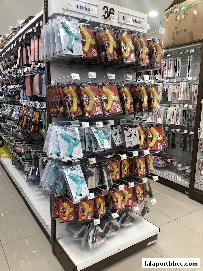 A display of hot glue guns and other DIY tools on shelves in a retail store.