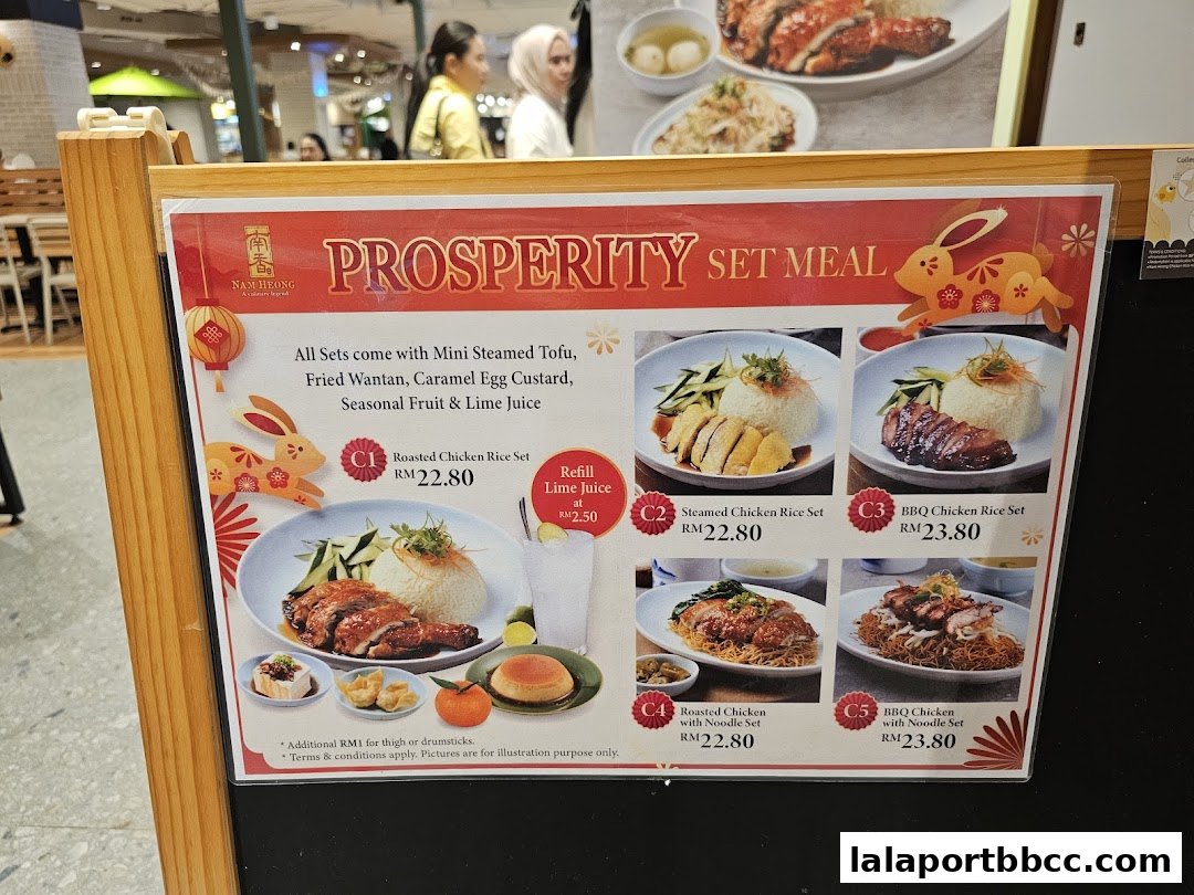 A menu board for Nam Heong Chicken Rice featuring Prosperity Set Meals with various chicken rice options.