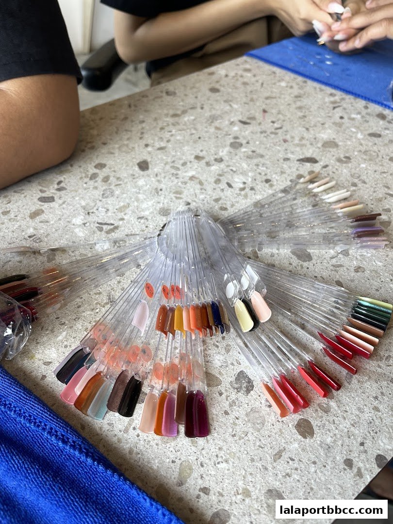 A selection of nail polish color swatches displayed on a table at a nail salon.