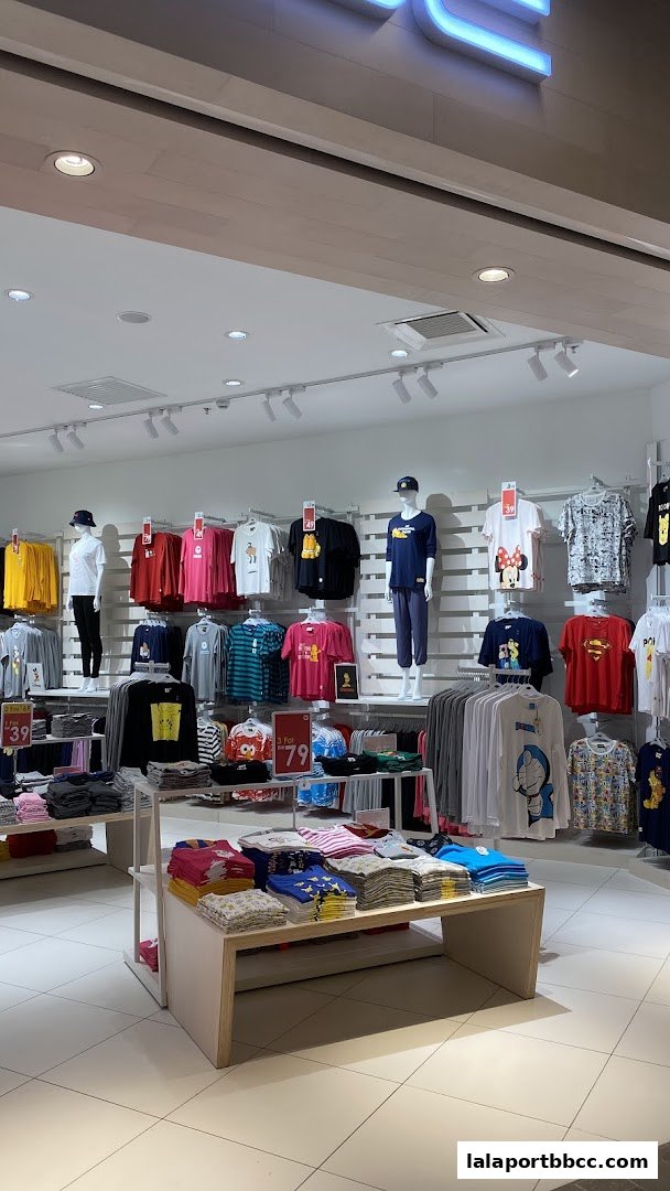 A well-lit retail store interior showcasing a wide variety of graphic t-shirts and apparel.