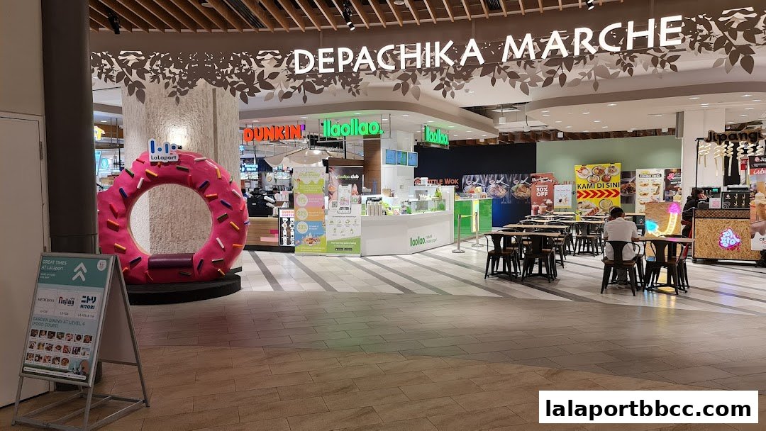 A food hall with various eateries, seating areas, and a large donut decoration.