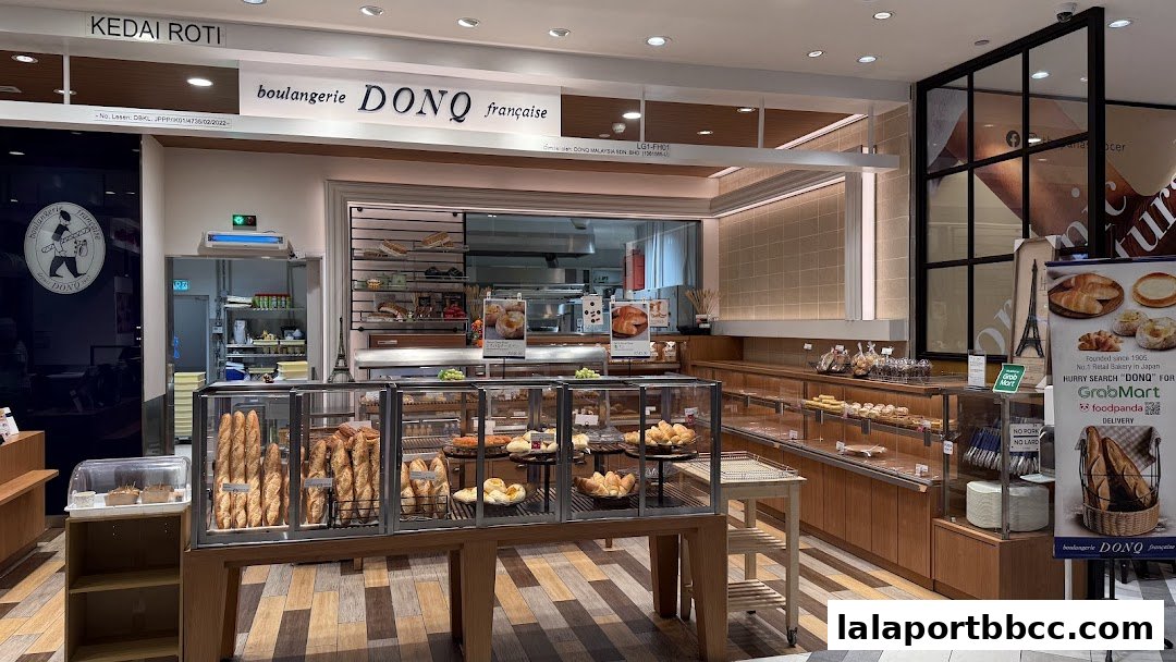 Interior view of a DONQ bakery showcasing a variety of fresh bread and pastries in display cases.