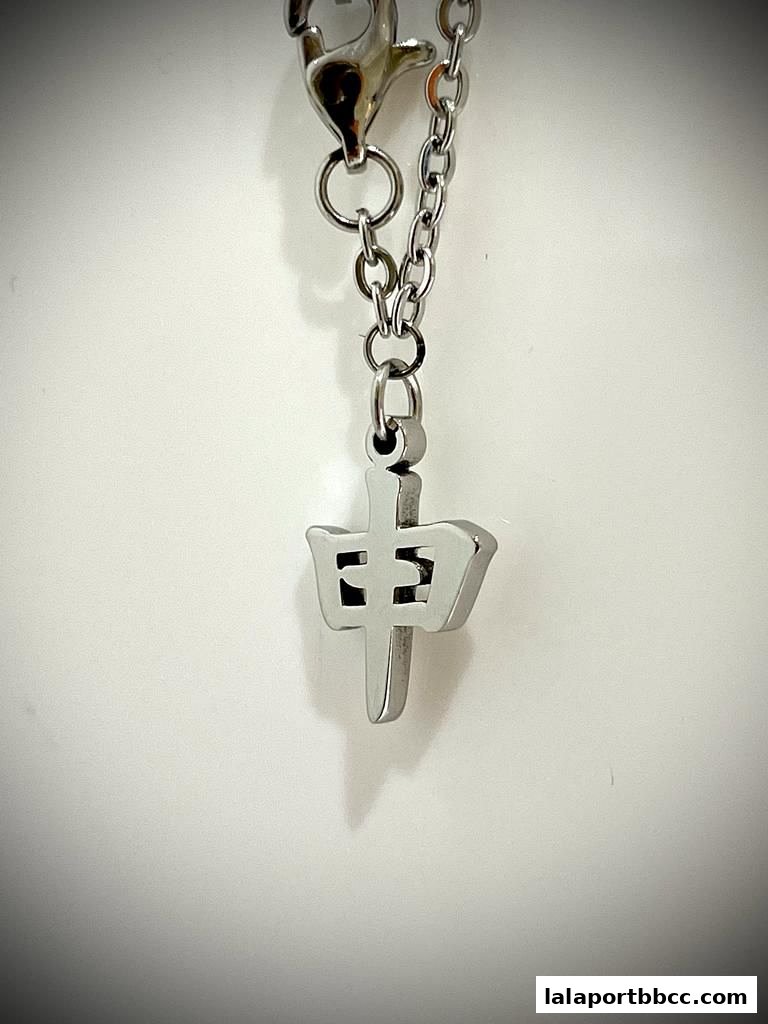 A close-up of a silver pendant with a Chinese character on a chain.