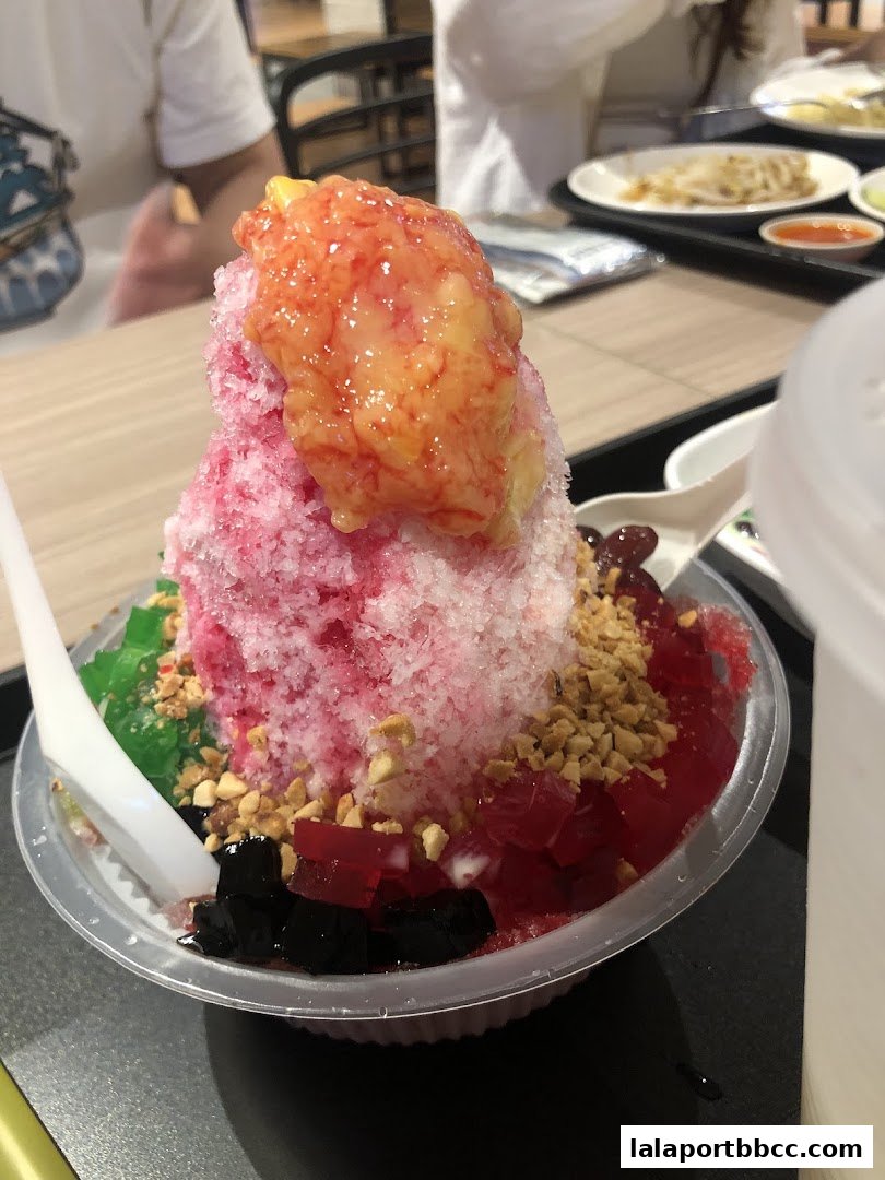 A close-up of a colorful shaved ice dessert with various toppings and jellies.