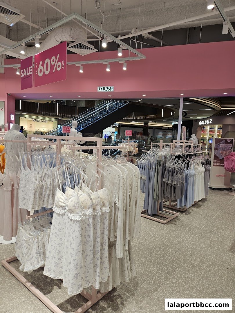 Interior of a lingerie shop with racks of sleepwear and a sale sign.