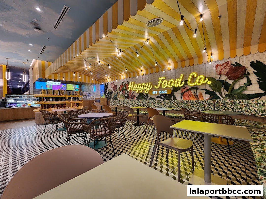 Interior of a brightly decorated cafe with yellow striped ceiling and floral wall art.