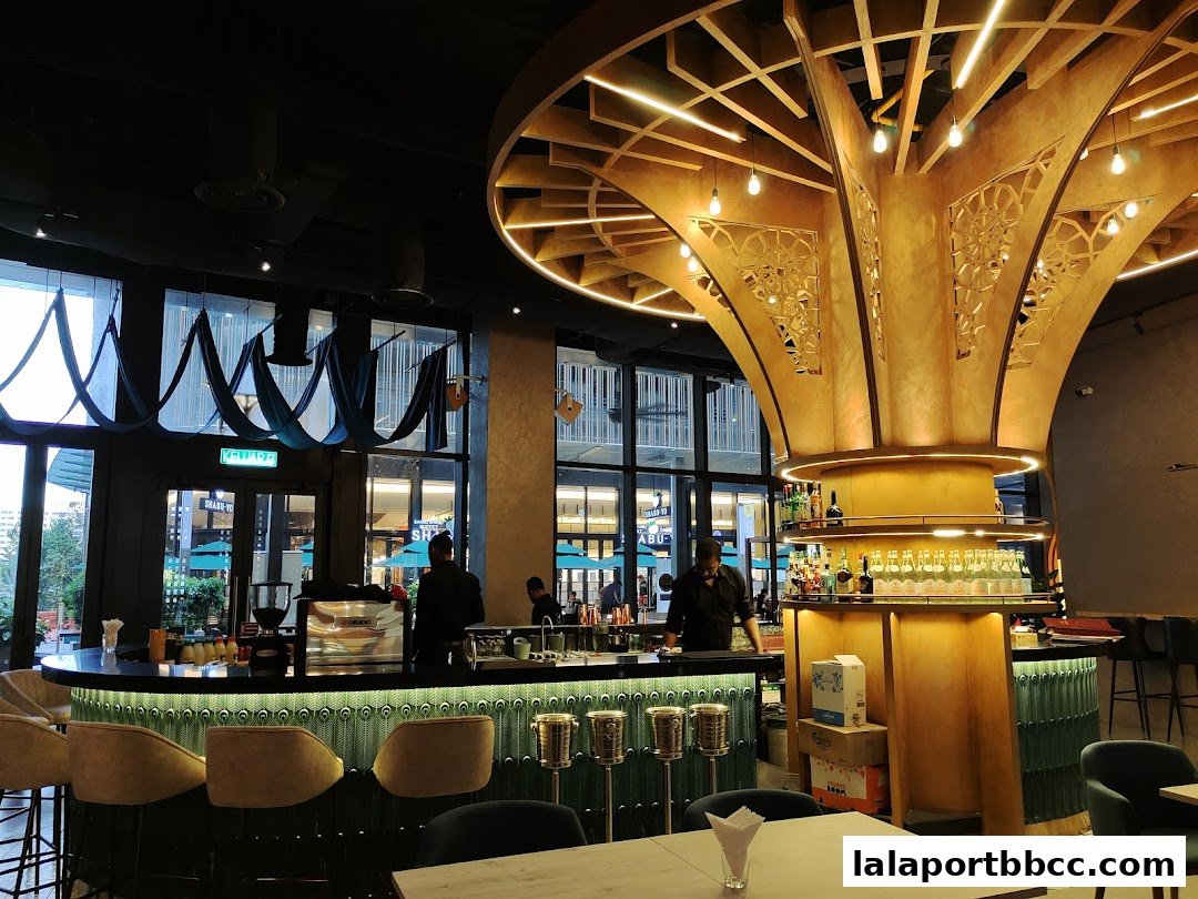 Interior of a stylish bar with a large decorative pillar and a well-stocked bar counter.