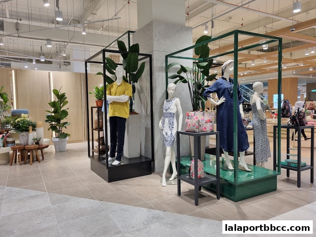 Mannequins display fashion apparel and accessories in a well-lit retail store.
