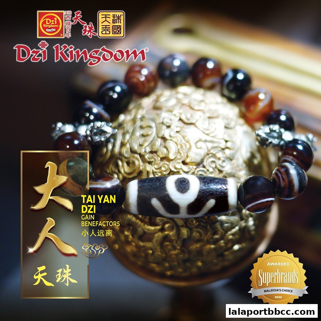 A close-up of a Dzi bead bracelet with auspicious Chinese characters and branding.