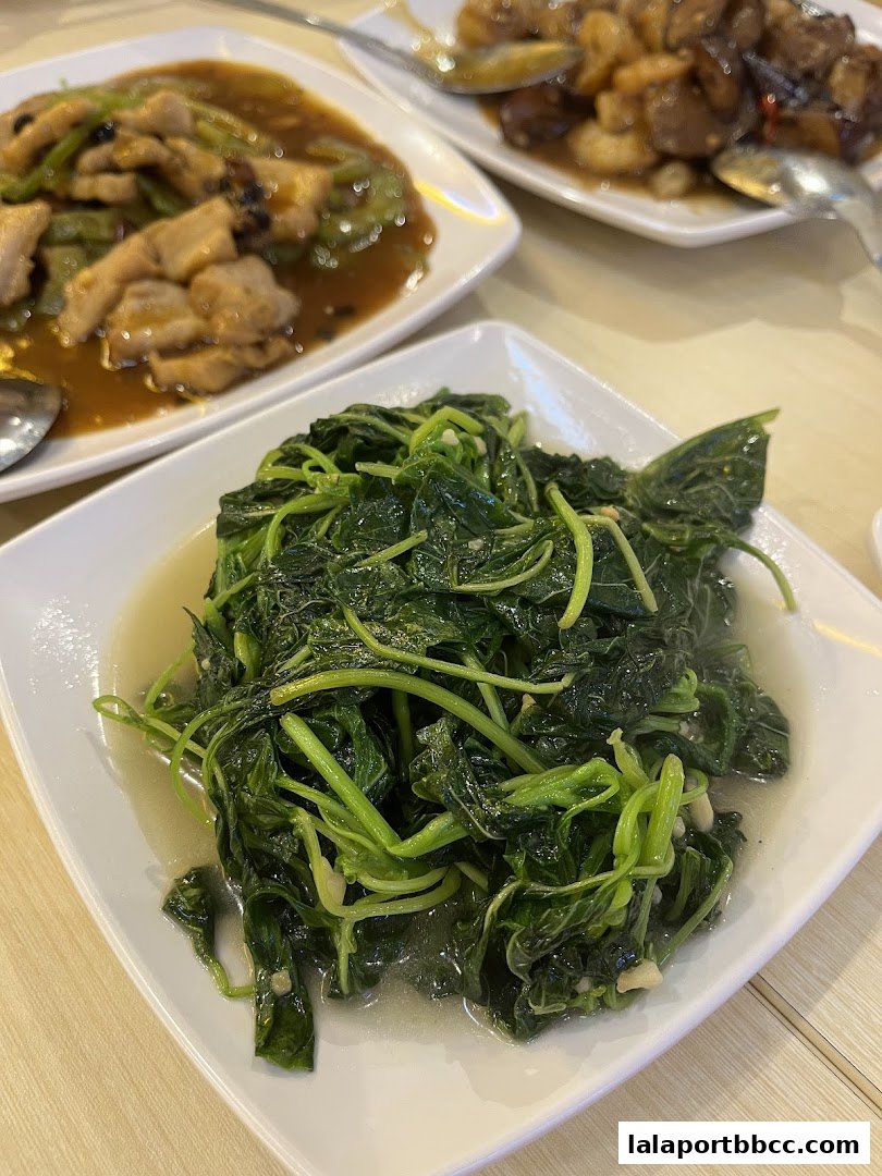 A close-up shot of a plate of stir-fried leafy green vegetables with garlic.