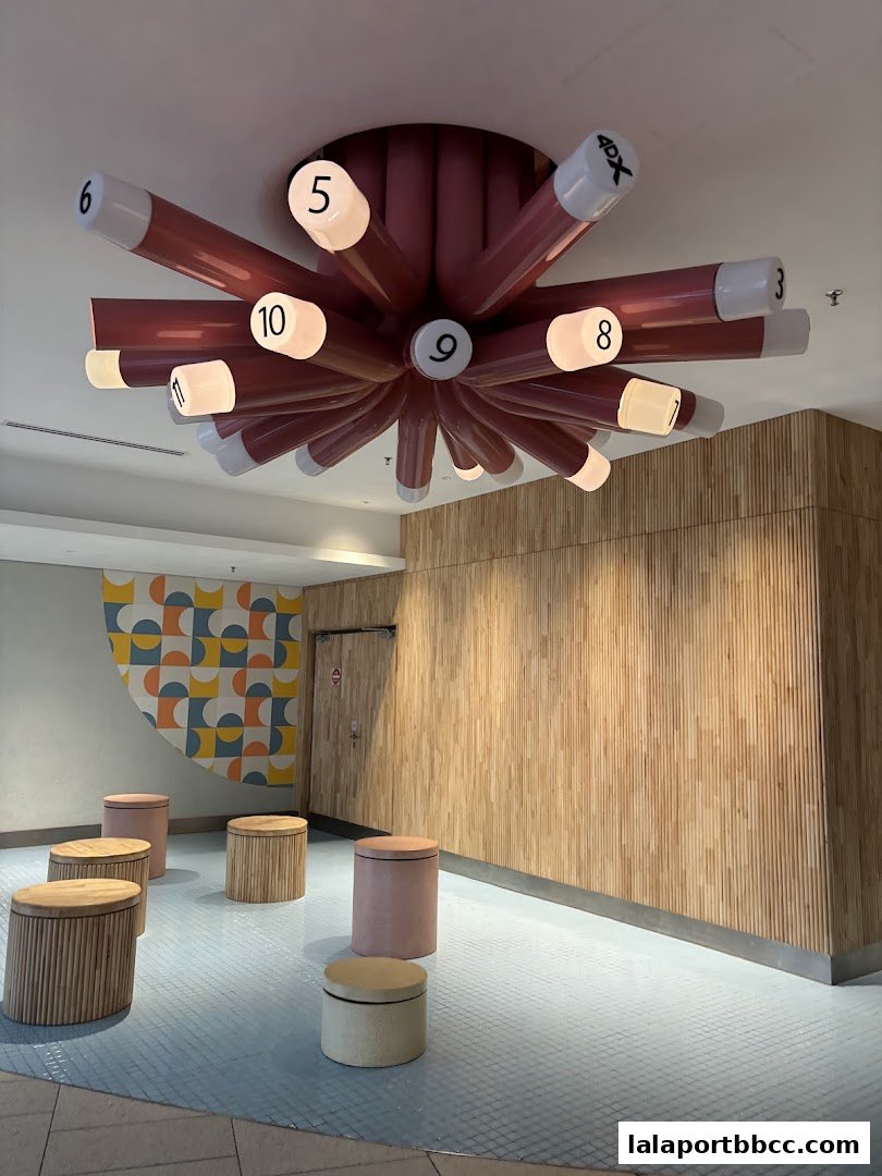 A waiting area with unique seating and a starburst-style light fixture with numbered bulbs.