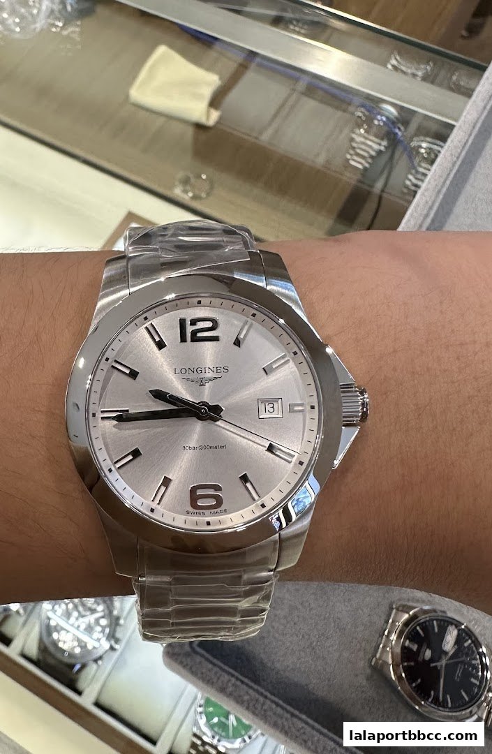 A close-up shot of a Longines watch on a wrist, with other watches displayed in the background.