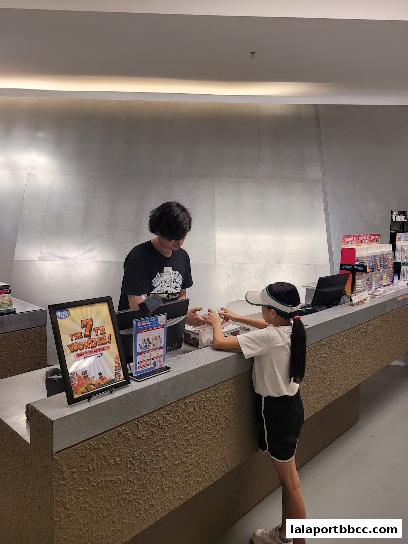 A cashier serves a young customer at a counter with promotional displays.