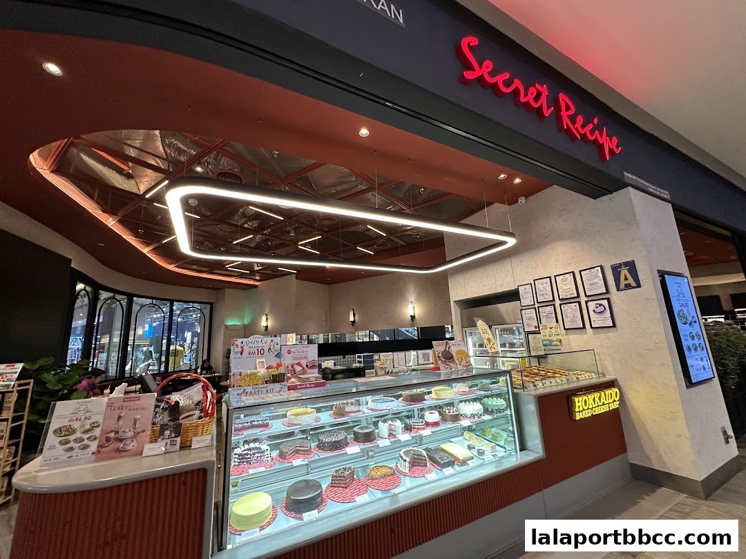 The exterior of a Secret Recipe bakery showcasing a display of various cakes and pastries.