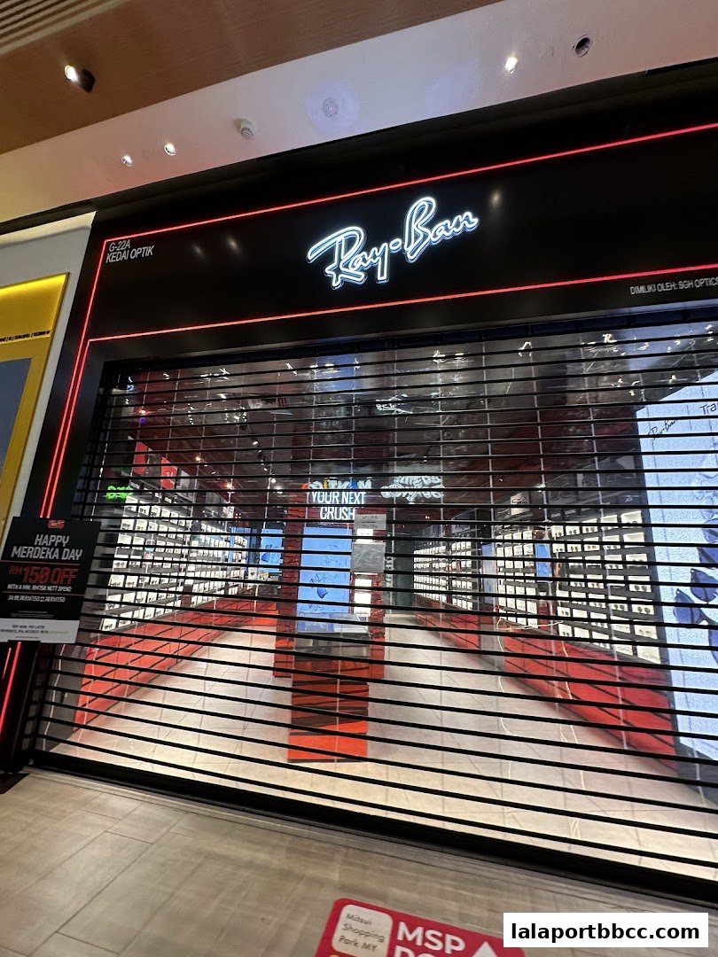 The Ray-Ban store front with its iconic logo and a closed roller shutter.
