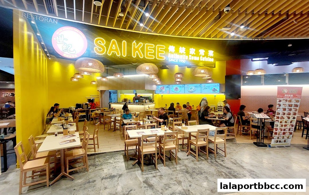 Interior view of Sai Kee Restaurant with customers dining and a bright yellow wall.
