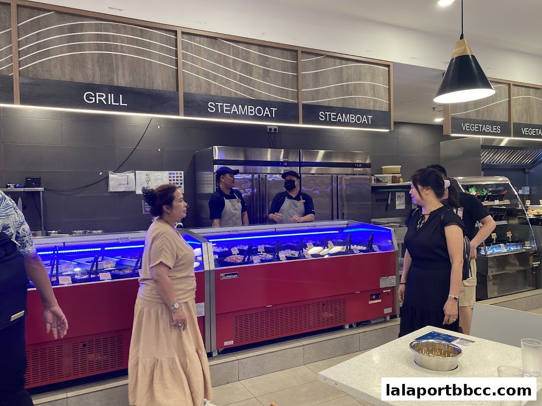 Customers browse food options at Seoul Garden, with staff serving behind a display counter.