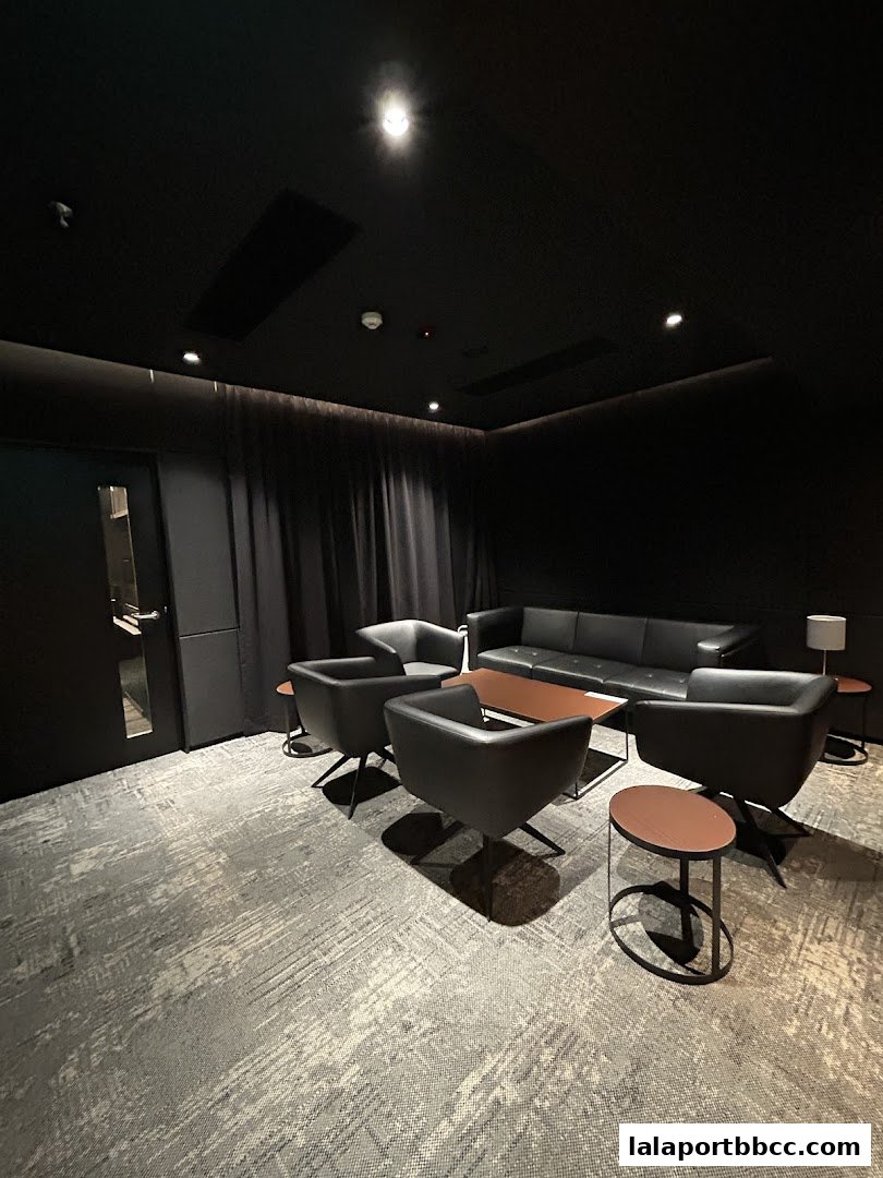 A modern lounge area with black leather seating and a coffee table.