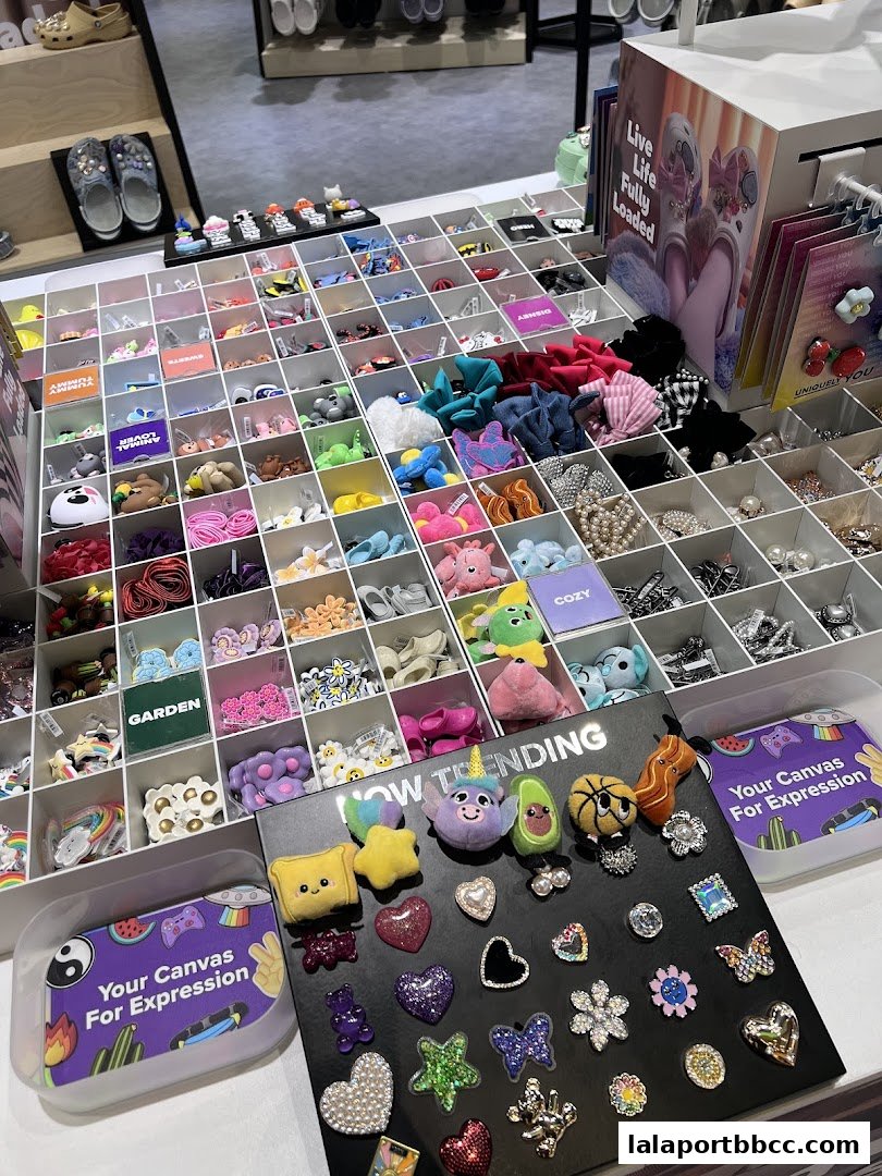 A display of colorful Crocs charms and accessories organized in compartments.