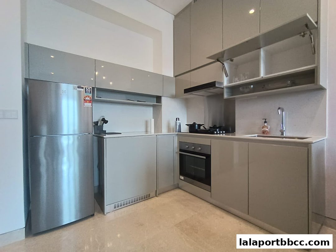 A modern, sleek kitchen with stainless steel appliances and light gray cabinetry.