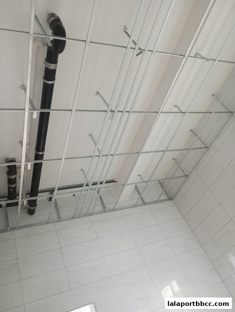 A view of a ceiling under construction with exposed pipes and metal framing.