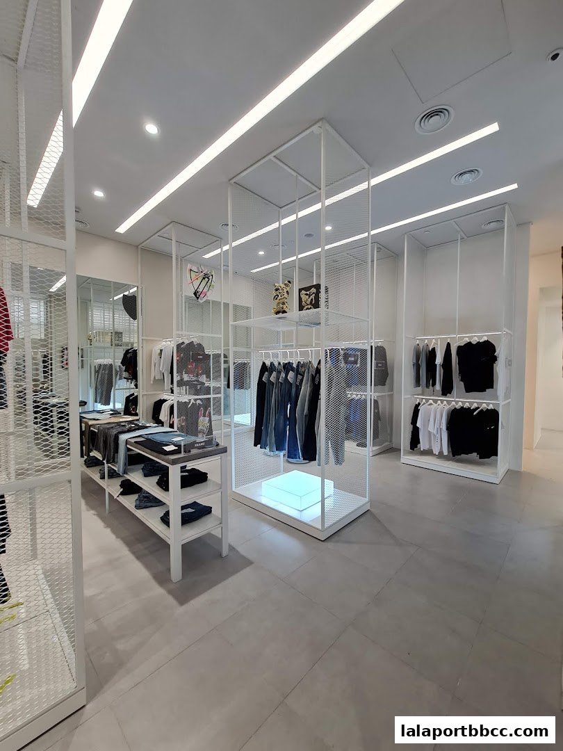 Interior view of a modern clothing store with minimalist displays and apparel.