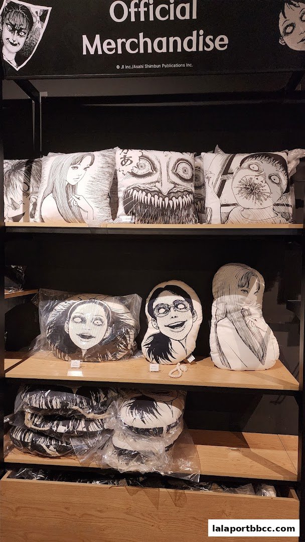 Shelves display various Junji Ito themed merchandise, primarily pillows with iconic horror manga artwork.