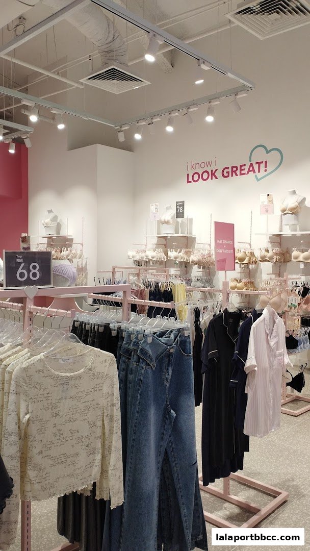 Interior view of a clothing store displaying various apparel, including bras, jeans, and tops.