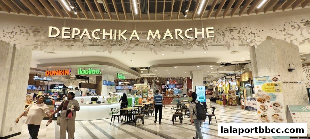 A food hall with various eateries and seating areas, featuring a large sign for Depachika Marche.