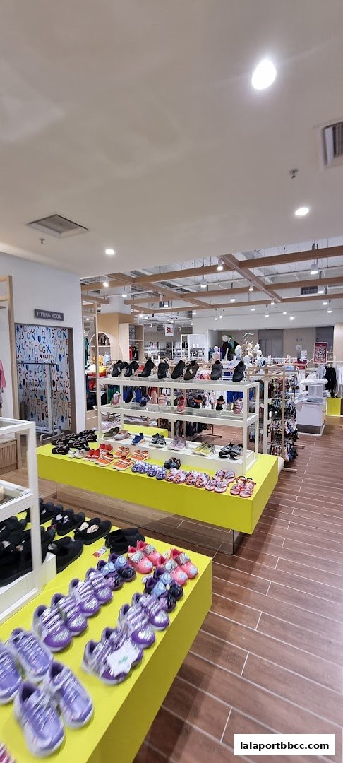 A well-lit shoe store interior with shelves displaying various footwear for children and adults.