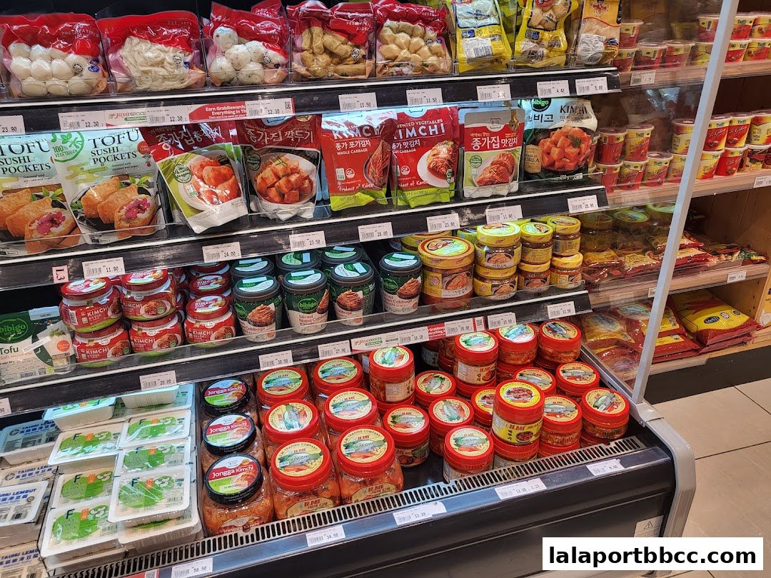 A display of various Korean food products, including kimchi, tofu, and sushi pockets.