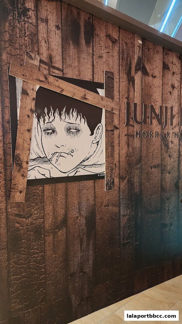 The entrance to the Junji Ito Horror House features a wooden facade with a striking illustration of a character.